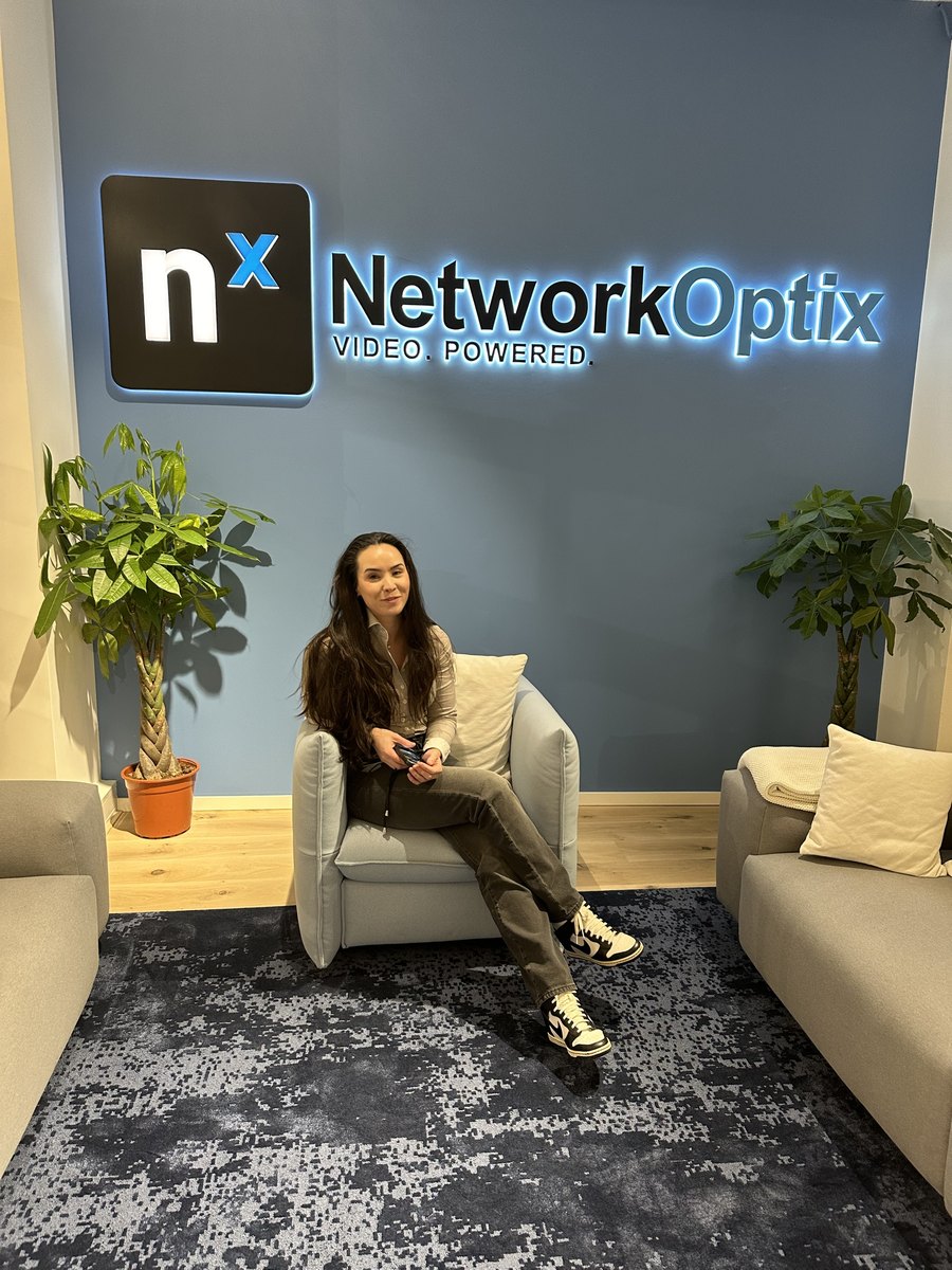 Eline Klaver, technisch specialist bij CameraInstallatie.nl, onder het verlichte logo van Network Optix