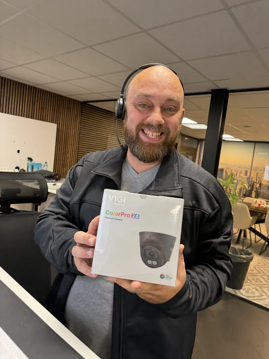 Marc Herdes op kantoor met de doos van de zwarte VIGI ColorPro 2.0-turretcamera